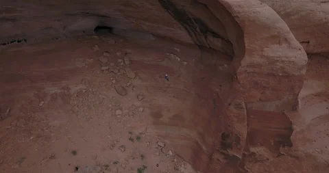 Aerial view of man rappelling down into sandstone amphitheatre Video stock 111362757