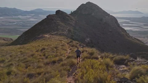 Aerial View of Man Running Down Coastal Mountain Ridge Trail Stock Footage 345026368