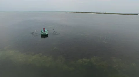 Aerial view - man sailing on a small rowboat. Video stock 68610984