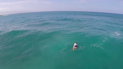 Aerial view of a man sitting while sup stand-up paddleboard surfing in Hawaii, t 스톡 동영상 70493222