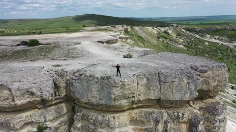 Aerial view of man standing on cliff in the Crimea. Rock AK-Kaya in Belogorsk. Stock Footage 315208922