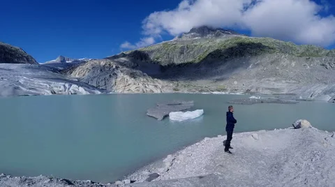 Aerial view of man standing in front of glacier lake looking at landscape Stock Footage 42253673