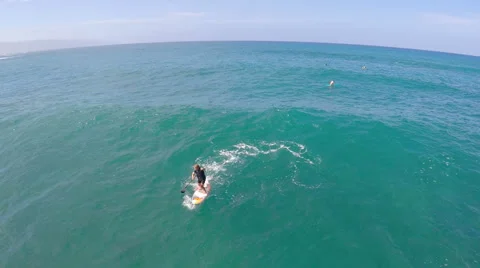 Aerial view of a man sup stand-up paddleboard surfing in Hawaii. Stock Footage 68588542