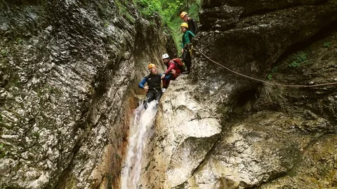 Aerial view of man throwing himself through a sliding rock at Soca river. Stock Footage 91174955
