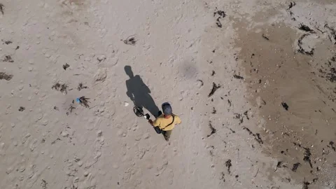 Aerial view of man using metal detector on sandy beach, searching for treasure Stock Footage 318883656