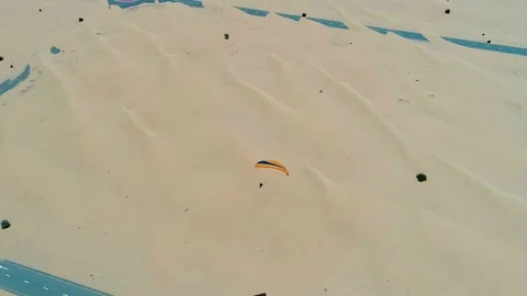 Aerial view of a man using powered parachute at desert landscape, Dubai, U.A.E. Video stock 103063389