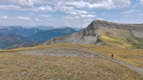 Aerial View of Man Walking Alone Through Mountains Stock Footage 338006300