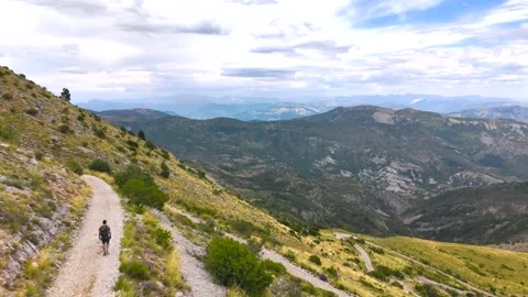 Aerial View of Man Walking Alone Through Mountains Stock Footage 338006408