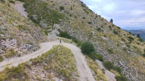 Aerial View of Man Walking Alone Through Mountains Stock Footage 338006532