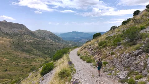 Aerial View of Man Walking Alone Through Mountains Stock Footage 338006614