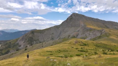 Aerial View of Man Walking Alone Through Mountains Stock Footage 338006619