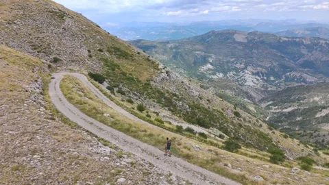 Aerial View of Man Walking Alone Through Mountains Stock Footage 338006648
