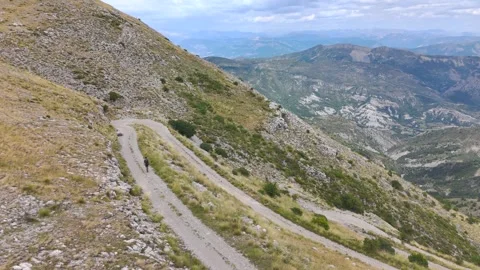Aerial View of Man Walking Alone Through Mountains Stock Footage 338006679