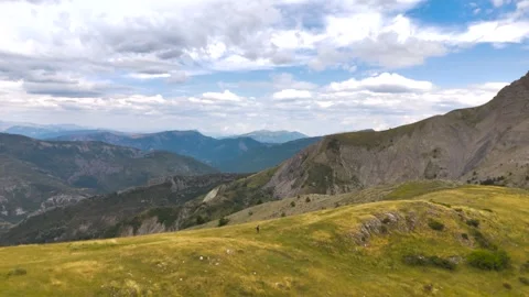 Aerial View of Man Walking Alone Through Mountains Stock Footage 338006847