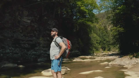 Aerial view of a man walking along a river in a mountain canyon. Stock Footage 265563820