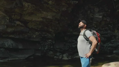 Aerial view of a man walking along a river in a mountain canyon. Stock Footage 265564106