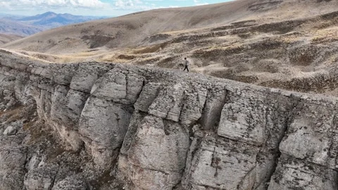 Aerial view of man walking on cliff top 2 Stock Footage 294087989