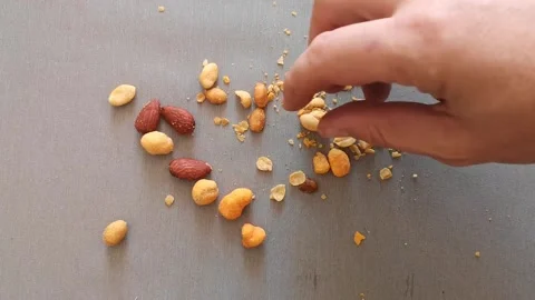 Aerial view of a man's hand picking up a dry fruit from those that are scattered Stock Footage 237103514