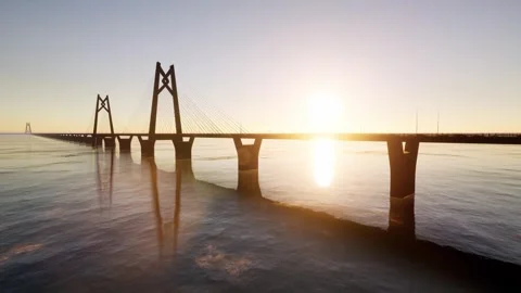 Aerial View of Massive Cable Stayed Bridge Spanning Ocean at Sunset Stockbeeldmateriaal 339072741