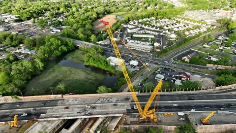 Aerial View of a Massive Crane Parked on a Highway Overpass Stock Footage 240694887