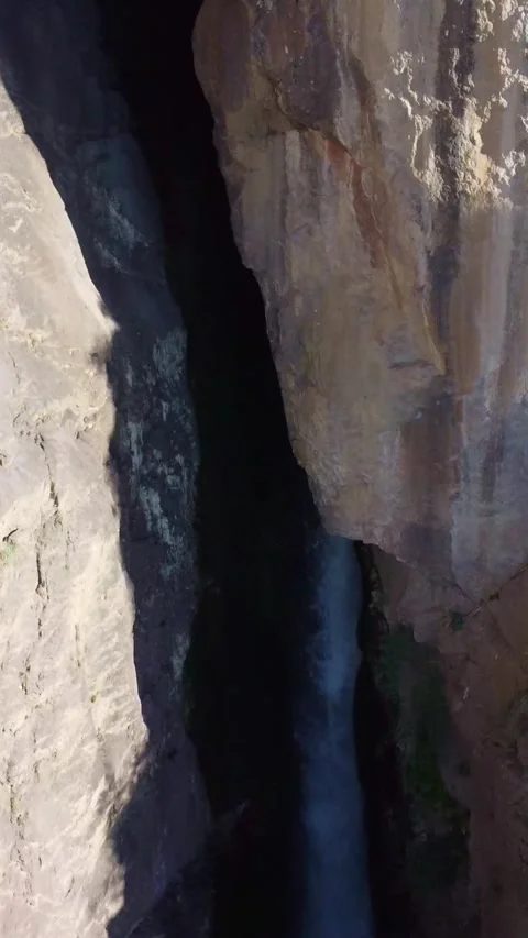 Aerial view of massive limestone rock wall and dark canyon cavern in Kazakhstan Stock Footage 338128942