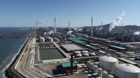 Aerial View of Massive Refinery Plant with Smokestacks and Red Bridge Over Ocean 库存影片 334637880