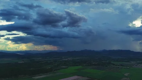 Aerial view of Massive storm clouds over agricultural valley with dramatic sky Stock Footage 314415122