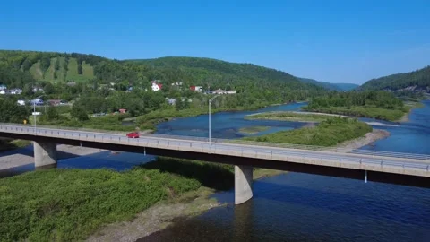 Aerial view of the Matapedia River with a red car crossing a bridge. Stock Footage 341678874