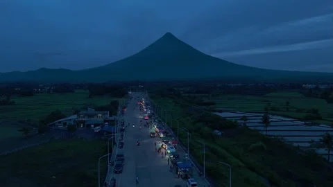 Aerial view of Mayon Volcano towering above bypass road at blue hour. Stock Footage 336870492