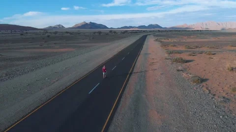 Aerial view of me walking alone on the road in the Namib desert,  Africa Stock Footage 155434614