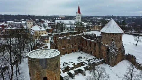 Aerial view of medieval castle ruins and Cesis town during winter snowfall in Stock Footage 346595071