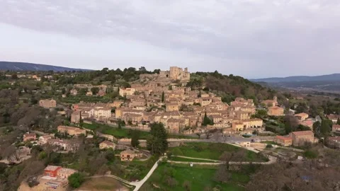 Aerial view of medieval Lacoste rooftops and castle at dawn in Provence Stock Footage 313149876