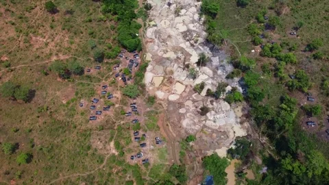 Aerial view of a mining operation site with barren land and dense vegetation Stock Footage 307895412