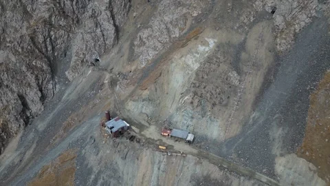 Aerial view of mining site with camera zooming in on machinery and terrain Video stock 319544102