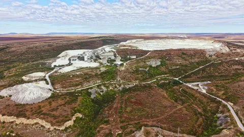 Aerial view of mining site with machinery and land features in rural area during Stock Footage 345455680