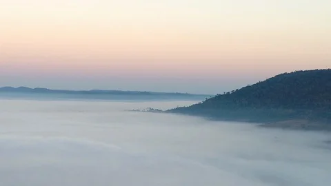 Aerial view of mist Covering a Mountain at Sunrise Stock Footage