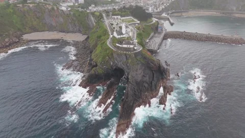 Aerial view of a misty cape with lighthouse and harbour Stockbeeldmateriaal 343325251