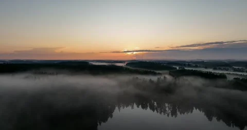 Aerial view of misty lake and forest at dusk Stock Footage 258570053