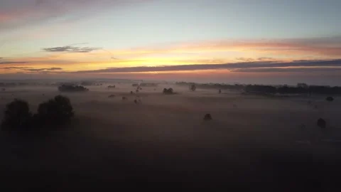Aerial view of a misty landscape during sunrise Stock Footage 220672022
