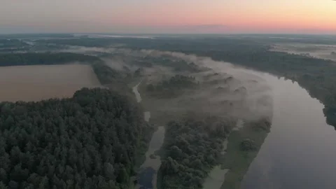 Aerial view of a misty winding river in the middle of a forest in a remote rural 스톡 동영상 140243142