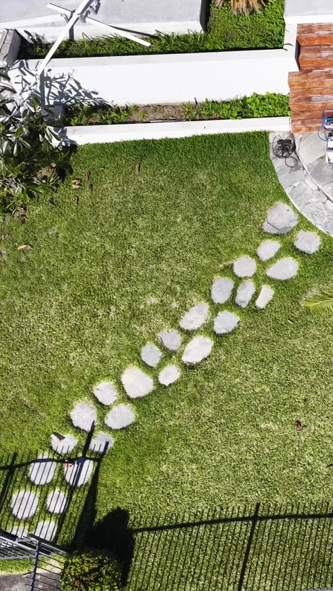 Aerial View of Modern Backyard Garden with Stone Path and Lawn Stock Footage 338424676