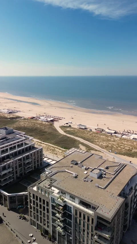 Aerial view of a modern beachside development with apartment buildings, sand Stock Footage 310879064