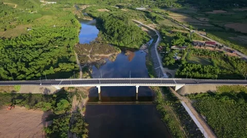 Aerial view of modern bridge crossing lush valley river Stock Footage 336610357
