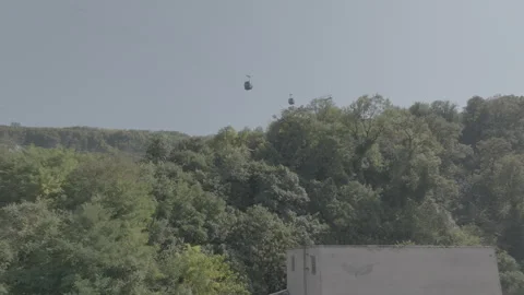 Aerial view of the modern cable car passing by old buildings in Chiatura Stock-Footage 254693832