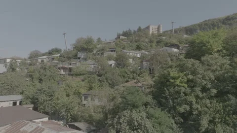 Aerial view of the modern cable car passing by old buildings in Chiatura Vídeo Stock 254710535