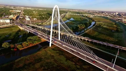 Aerial View of Modern Cable-Stayed Bridge Spanning River and Urban Landscape Stock Footage 311728141