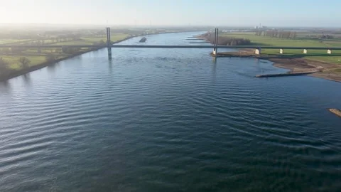 Aerial view of a modern cable stayed bridge crossing a wide river at sunrise Video stock 329810179