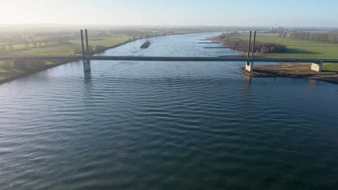 Aerial view of a modern cable stayed bridge crossing a wide river at sunrise Stock Footage 331851939