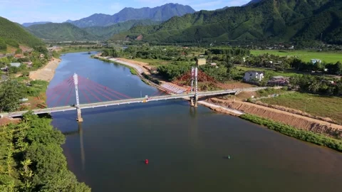 Aerial  view of a modern cable-stayed bridge over a river in a rural landscape Stock Footage 336610224