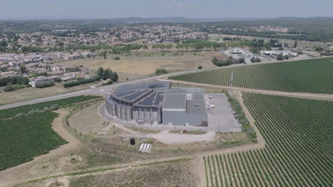 Aerial view of a modern circular winery building with solar panels surrounded by Stock Footage 337992303